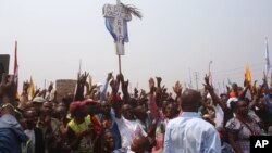 Supportes of Congo opposition leader Etienne Tshisekedi, rear, hold up a cross that symbolizes no third term for Congo President Joseph Kabila, during a political rally in Kinshasa, Congo, Wednesday, July 31, 2016.