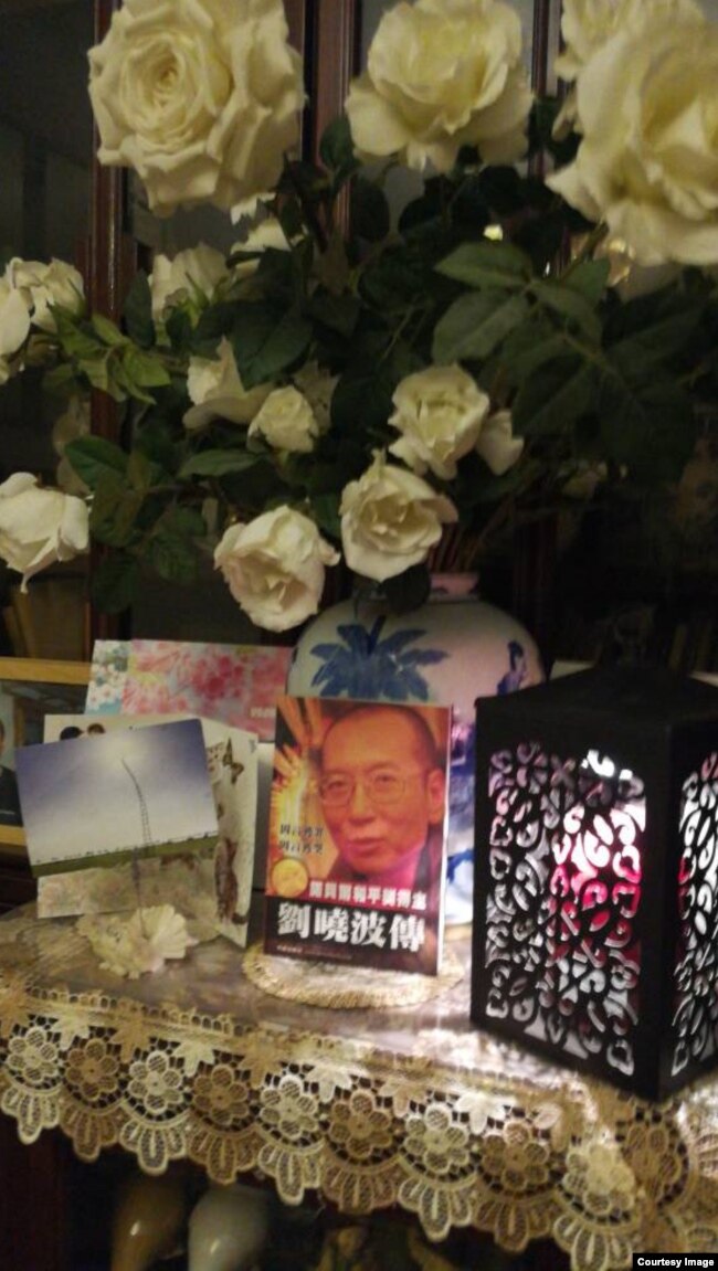2017年7月19日凌晨，悼念者家中燃烛摆花祭奠刘晓波。（推特图片）