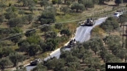 Tanques sirios vistos desde la aldea turca de Hatay Saribuk en la provincia a lo largo de la frontera turco-siria.