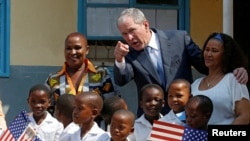 Former US President George W. Bush greets children at a school in Gaborone, Botswana, April 4, 2017.