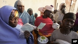 People stand in a food line at the small town of Tchadoua around 40 kilometers from the town of Maradi, Niger.
