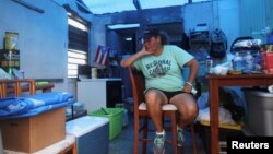 Jazmin Morales sits in her kitchen without power and with a plastic sheet replacing the roof after Hurricane Maria hit the island in September, in Yabucoa, Puerto Rico, Jan. 29, 2018. 