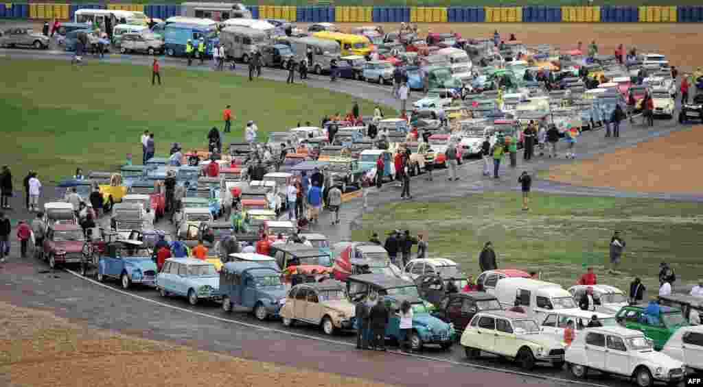 Citroen owners take part in a 2CV parade during the &quot;Euro Citro 2014&quot;, on the circuit of Le Mans, western France. Almost 2,500 Citroen cars - DS, Traction Avant, TUB, 2 CV - took part in the event dedicated to French carmaker Citroen&#39;s fans and car owners. &nbsp;