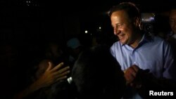 Juan Carlos Varela of the Panamenista Party (PP) shakes hands with supporters during his first public presentation as the elected president of Panama outside the Virgin of Carmen church in Panama City, May 5, 2014. 