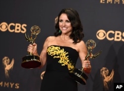 Julia Louis-Dreyfus poses in the press room with her awards for outstanding lead actress in a comedy series and outstanding comedy series for "Veep" at the 69th Primetime Emmy Awards, Sept. 17, 2017, at the Microsoft Theater in Los Angeles.