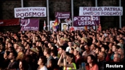 FILE - Supporters attend the last campaign rally of the coalition Unidos Podemos (Together We Can) for Spain's upcoming general election in Madrid, Spain, June 24, 2016. 