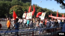 9月18日北京反日示威者手持毛泽东像。韩德强打了对毛泽东持不同政见的老人