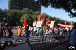 9月18日北京反日示威者手持毛泽东像。韩德强打了对毛泽东持不同政见的老人