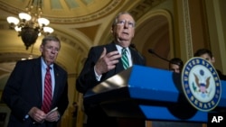 Senate Majority Leader Mitch McConnell of Ky., right, accompanied by Senate Veterans Affairs Committee Chairman Sen. Johnny Isakson, R-Ga., speaks during a news conference on Capitol Hill in Washington.