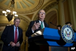FILE - Senate Majority Leader Mitch McConnell of Ky., right, accompanied by Senate Veterans Affairs Committee Chairman Sen. Johnny Isakson, R-Ga., speaks during a news conference on Capitol Hill in Washington.
