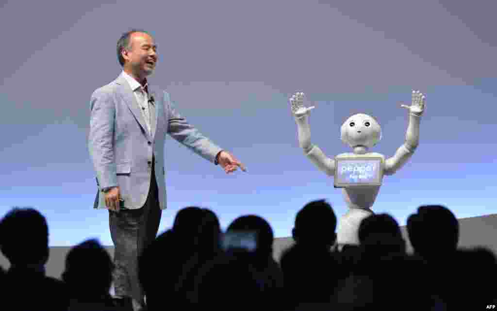 SoftBank Group representative Masayoshi Son and humanoid robot Pepper deliver a presentation at the SoftBank World 2015 in Tokyo, Japan.