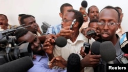 FILE - Somali journalist Abdiaziz Abdinur (R) talks to reporters after the high court freed him in the capital of Mogadishu, March 17, 2013.