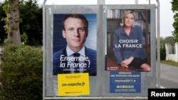 Official posters of the candidates for the 2017 French presidential election, Emmanuel Macron of the political movement En Marche! (Onwards!) and Marine Le Pen of the French National Front political party, are displayed in Saint-Josse, northern France, May 5, 2017.