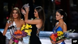 Former Miss Universe Paulina Vega, center, removes the crown from Colombia's Ariadna Gutierrez, left, before giving it to the Philippines' Pia Alonzo Wurtzbach, right, at the pageant in Las Vegas, Nev., Dec. 20, 2015.