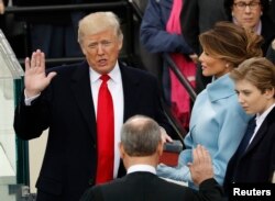 Donald Trump is sworn in as the 45th president of the United States by Chief Justice John Roberts as Trump's wife, Melania, and his son Barron look on the West front of the U.S. Capitol in Washington, Jan. 20, 2017.