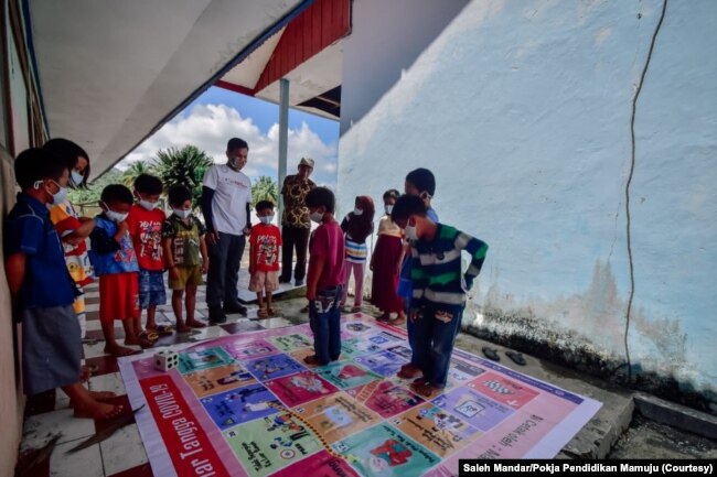 Salah satu materi pembejalaran yang dilakukan para relawan mengajar kampanye Taki Mi'guru adalah pemahaman tentang Covid-19 dengan permainan ular tangga, Senin, 15 Maret 2021. (Foto: Saleh Mandar/Pokja Pendidikan Mamuju)