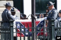 An honor guard from the South Carolina Highway patrol removes the Confederate battle flag from the Capitol grounds in Columbia, S.C., Friday, July 10, 2015, ending its 54-year presence there. (AP Photo/John Bazemore)