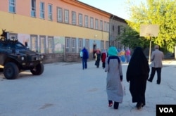People approach a polling place in Diyarbakir Sunday morning while Turkish troops stand by. (Mutlu Civiroglu/VOA)