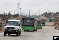 Buses sent to evacuate residents from al-Foua and Kafraya arrive at a rebel-held checkpoint on the outskirts of the two Syrian villages under rebel siege, Dec. 18, 2016.