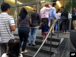 FILE - People line up outside the building that houses the immigration courts in Los Angeles, June 28, 2018.