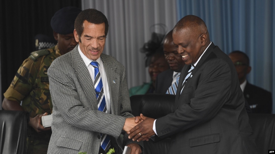 FILE - Botswana's then-President Ian Khama, left, shakes hands with his vice president and current Botswana President Mokgweetsi Masisi during a rally in Serowe, Botswana, on March 27, 2018, four days before officially stepping down as president.
