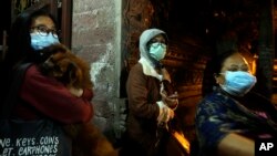 Villagers wear masks as they prepare to evacuate from their homes near the crater of Mount Agung at Besakih village, Karangasem, Bali, Indonesia, Nov. 25, 2017. A volcano on the Indonesian tourist island erupted for the second time in a week on Saturday, 