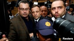 Olympic and Paralympic track star Oscar Pistorius (C) leaves after his trial at the North Gauteng High Court in Pretoria, South Africa, March 4, 2014.