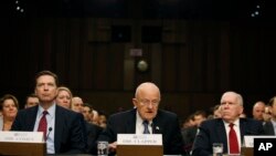 FILE - From left, FBI Director James Comey, Director of the National Intelligence James Clapper, CIA Director John Brennan, participate in a Senate Intelligence Committee hearing, Feb. 9, 2016, on Capitol Hill in Washington.