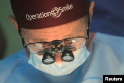 FILE - Operation Smile co-founder Bill Magee performs a facial deformity repair surgery for a patient, at the Vietnam Cuba hospital in Hanoi, Nov. 18, 2014.