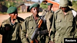 File - A child soldier (C), known as "Kadogo," meaning "small one" in Swahili, stands at the front line at Kanyabayonga in eastern Congo.