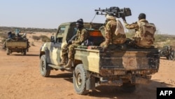 Des membres de l'Armée malienne (FAMA), du Groupe Autodefense Touareg Imghad et Alliés (GATIA) et du Mouvement pour le salut de l'Azawad (MSA) sont observés lors d'une patrouille mixte dans les environs du district du nord du Mali, le 19 avril 2017. 