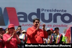 FILE - Venezuela's President Nicolas Maduro and his wife, Cilia Flores, take part in a campaign rally in Ciudad Guayana, Venezuela, April 23, 2018.