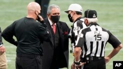 FILE - Atlanta Falcons owner Arthur Blank (C) speaks with referees before an NFL football game between the Falcons and the Panthers, Oct. 11, 2020, in Atlanta. Blank gave the University of Texas at Austin $20 million to create a new center for research into stuttering. (AP Photo)