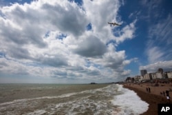 A seagull soars above the sea and under a cotton candy clouded sky on a beautiful Spring day at the seafront in Brighton, England