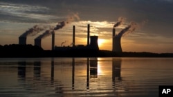  In this June, 3, 2017, file photo, the sun sets behind Georgia Power's coal-fired Plant Scherer, one of the nation's top carbon dioxide emitters, in Juliette, Ga. (AP Photo/Branden Camp, File)