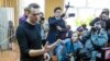 Russian opposition leader Alexei Navalny, foreground, speaks to press in a court room in Moscow, Russia, March 27, 2017. 