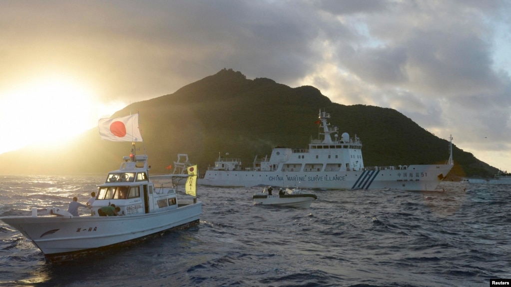 中国海监船51号（中）在东中国海域的钓鱼岛，日本称作尖阁列岛的有争议海岛旁航行，日本海岸警卫队的船只在旁（右），前船为日本渔船。（2013年7月1日）(photo:VOA)