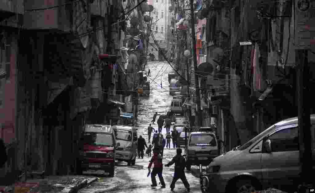 Syrians walk past damaged homes during heavy fighting between Free Syrian Army fighters and government forces in Aleppo, Syria, December 4, 2012. 