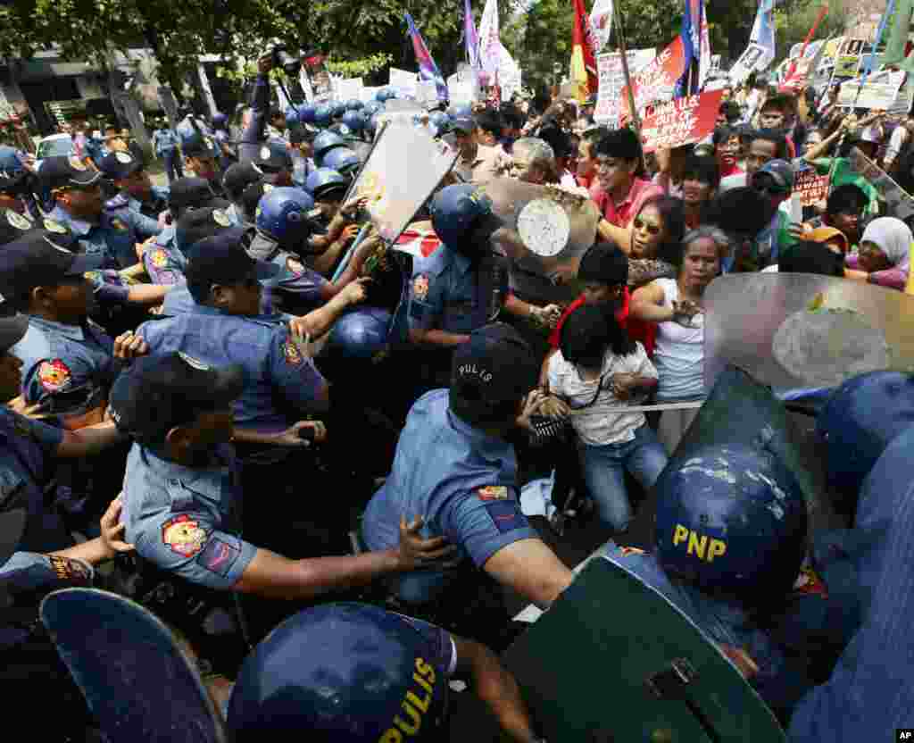 Polisi dan demonstran bentrok saat para demonstran mendesak untuk mendekati Kedutaan Besar AS di Manila dalam protes menolak kunjungan Presiden AS Barack Obama (23/4). (AP/Bullit Marquez)