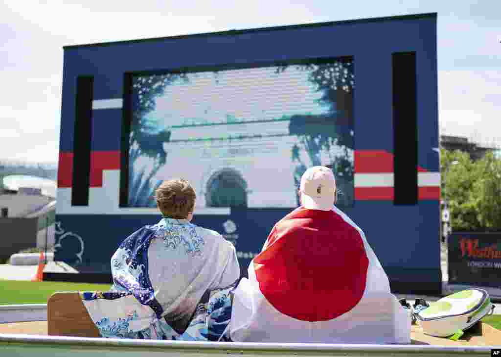 Fans watch the opening ceremony of the Tokyo 2020 Olympic Games on a big screen at the Team GB Tokyo 2020 Olympics fanzone, at Westfield, London, Friday July 23, 2021, which will be open for the next 17 days. (Dominic Lipinski/PA via AP)