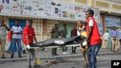 Abakozi bakora mu gisata c'Ubuganga batwaye ikiziga c'umuntu yishwe na bombe in Mogadishu, Somalia, itariki 25/03/2018. 