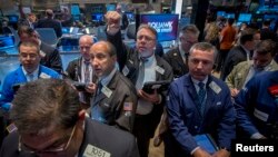 FILE - Traders gather at the post where Alibaba Group Holding Ltd is traded on the floor of the New York Stock Exchange, Sept. 22, 2014. 