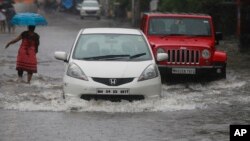 Vehicles navigate their way through a flooded street in Mumbai, India, Sept. 20, 2017. Incessant rainfall in India's commercial capital has affected air and rail traffic.