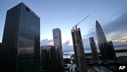 FILE - The Evergrande Group headquarters at left is seen near other skyscrapers and construction sites in Shenzhen in southern China's Guangdong province, Sept. 24, 2021. 