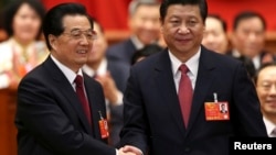 14일 중국 베이징의 인민대회당에서 열린 전국인민대표대회 12기 1차회의에서, 새로 선출된 시진핑 국가주석(오른쪽)이 전임자인 후진타오 주석과 악수하고 있다.