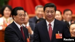 Hu Jintao (kiri) menjabat tangan Ketua Komisi Militer Pusat dan Presiden China yang baru terpilih, Xi Jinping, seusai pemungutan suara di Kongres Rakyat Nasional (NPC) di Beijing (14/3). 
