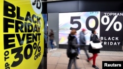 FILE - Shoppers walk past Black Friday signage on Oxford Street in London, Britain, November 23, 2018. (REUTERS/Toby Melville)