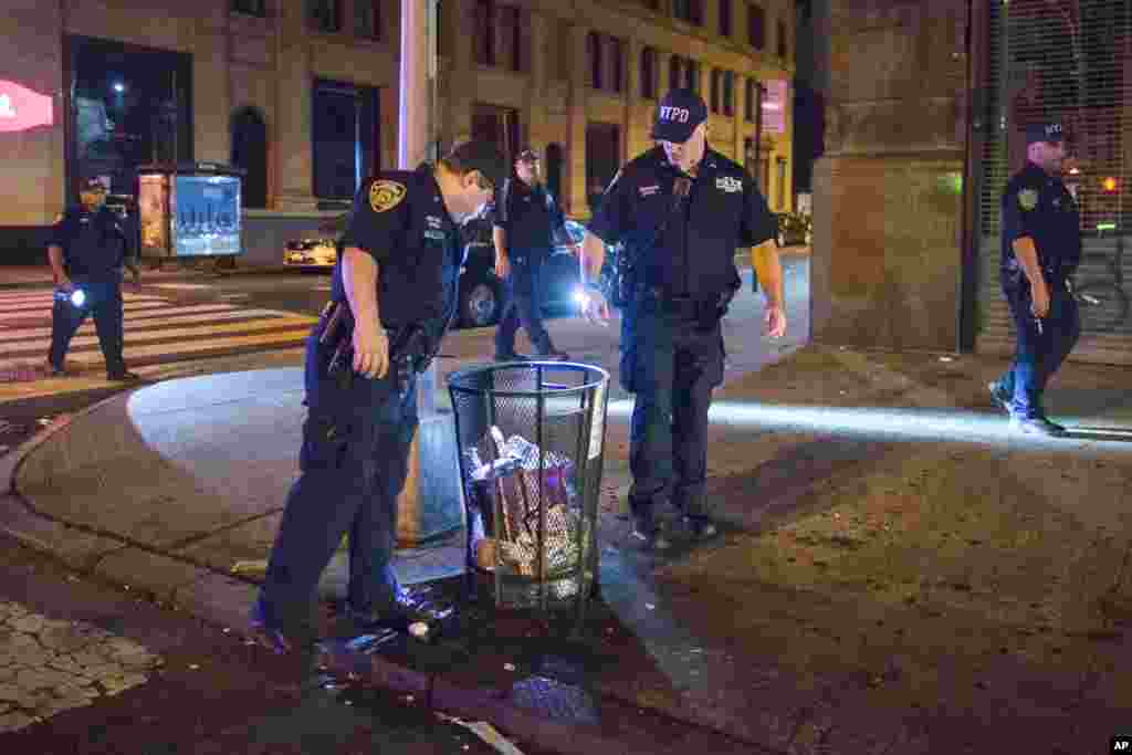 Police officers look for suspicious packages along Fifth Avenue near the scene of an explosion on West 23rd Street and 6th Avenue in Manhattan&#39;s Chelsea neighborhood in New York, Sept. 18, 2016.
