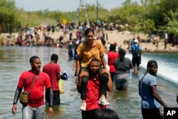 FILE - Haitian migrants use a dam to cross into the United States from Mexico, Sept. 18, 2021, in Del Rio, Texas.