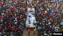 Relatives of garment workers who were working in the Rana Plaza building when it collapsed, gather around a truck carrying dead bodies, in Savar, 30 km (19 miles) outside Dhaka, April 27, 2013. 